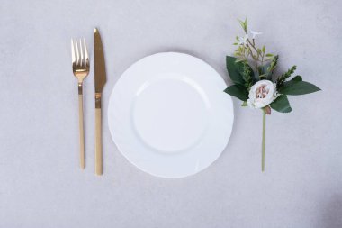 Beyaz gül, çatal bıçak takımı ve beyaz yüzey. Yüksek kalite fotoğraf