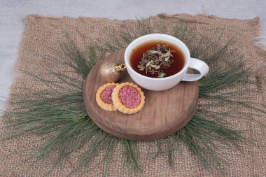 Bir fincan bitki çayı, Noel topu ve ahşap tabakta kurabiyeler. Yüksek kalite fotoğraf