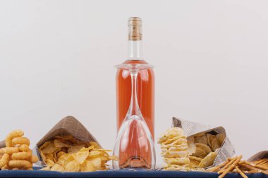 Beyaz masada çeşitli aperatiflerle birlikte bir şişe gül şarabı. Yüksek kalite fotoğraf