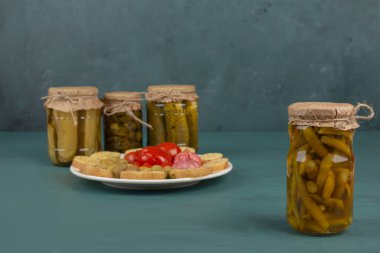 Kavanozlar dolusu sebze turşusu ve salamura edilmiş sebzeler mavi masada. Yüksek kalite fotoğraf