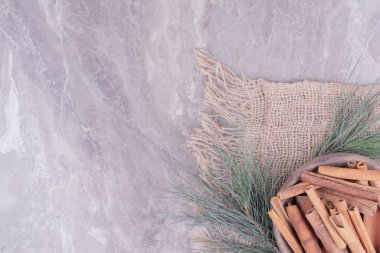 Tarçın, etrafı meşe dallarıyla çevrili ahşap bir kaba yapışır. Yüksek kalite fotoğraf