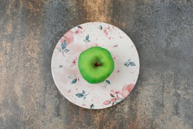 Mermer zemin üzerinde güzel bir tabakta soyulmuş yeşil elma. Yüksek kalite fotoğraf