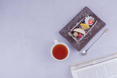 Bir dilim çikolatalı kek, bir fincan çay ve meyveli. Yüksek kalite fotoğraf