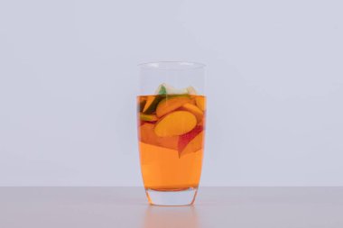 Beyaz arka planda meyve dilimleri olan bir bardak meyve suyu. Yüksek kalite fotoğraf