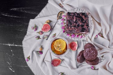 Siyah arka planda bir dilim çikolatalı cheesecake ve bir bardak bitki çayı. Yüksek kalite fotoğraf