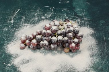 Mermer masa üzerinde toz ile süslenmiş siyah üzümler. Yüksek kalite fotoğraf