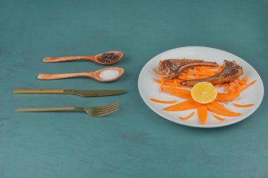 Beyaz tabakta kuzu pirzolası ve havuç dilimleri. Yüksek kalite fotoğraf