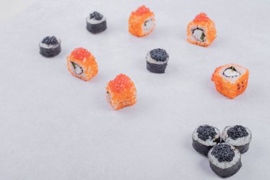 Maki ve California suşisi beyaz arka planda yuvarlanıyor. Yüksek kalite fotoğraf