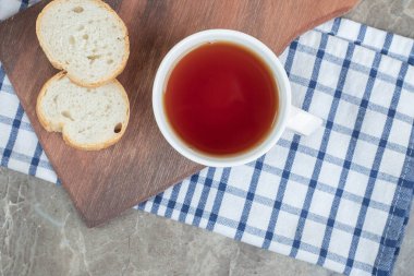 Tahta üzerinde ekmek dilimleri ve bir fincan çay. Yüksek kalite fotoğraf