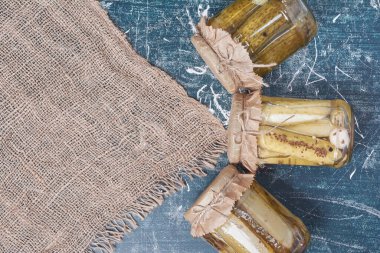 Mavi arka planda cam kavanozlarda salatalık turşusu. Yüksek kalite fotoğraf