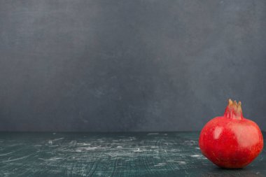 Mermer masanın üzerinde olgun bir nar var. Yüksek kalite fotoğraf