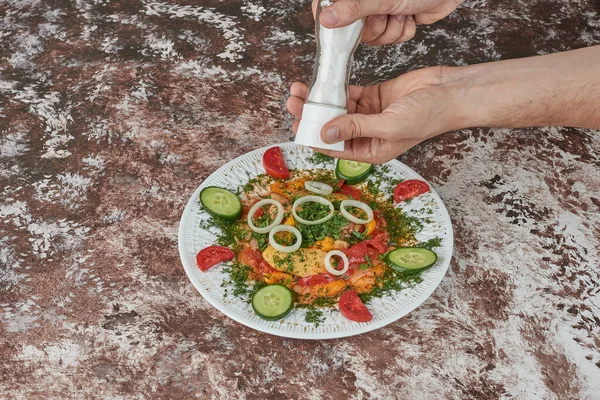 Adding salt to the vegetable salad. High quality photo