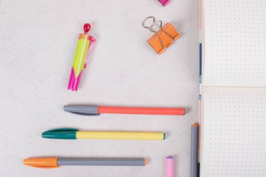 Beyaz arka planda açık not defteri olan beş renkli kalem. Yüksek kalite fotoğraf