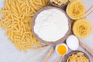 Tahta kaselerde, yumurta sarısı ve unla pişirilmemiş makarna. Yüksek kalite fotoğraf