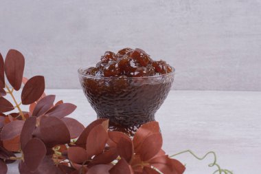 Bardakta meyve reçeli ve beyaz masa yaprakları. Yüksek kalite fotoğraf