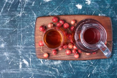 Kırmızı kirazlar ve mavi arka planda bir bardak içki. Yüksek kalite fotoğraf