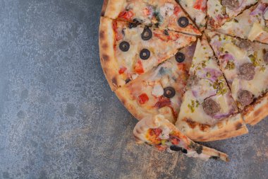 Mermer arka planda lezzetli doğranmış pizza.