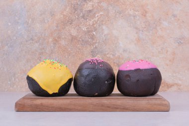 Tahtanın üzerinde renkli malzemelerle çikolatalı çörekler. Yüksek kalite fotoğraf