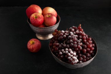 Metalik kaplarda kırmızı üzüm demetleri ve elmalar. Yüksek kalite fotoğraf