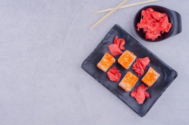 Philadelphia siyah seramik tabakta kırmızı zencefille yuvarlanıyor. Yüksek kalite fotoğraf