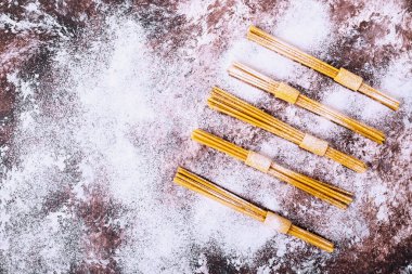 Kahverengi arka planda pişmemiş çiğ spagetti. Yüksek kalite fotoğraf