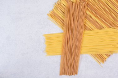 Beyaz arka planda iki adet çiğ spagetti makarna. Yüksek kalite fotoğraf