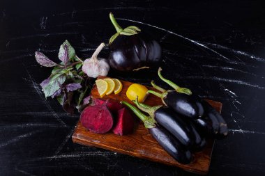 Siyah arka planda mor patlıcan ve diğer sebzeler. Yüksek kalite fotoğraf