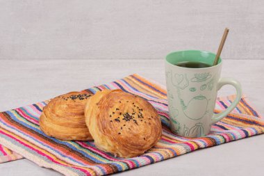 Masa örtüsünün üzerinde iki gogal ve bir fincan çay. Yüksek kalite fotoğraf