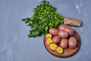 Bir kağıt parçasında dilimlenmiş patates ve otlar mavi arka planda. Yüksek kalite fotoğraf