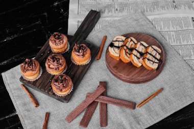 Tahta bir tahtanın üzerinde kakao kremalı kekler ve yuvarlak dilimler. Yüksek kalite fotoğraf