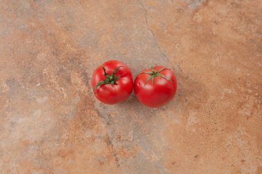 Mermer zemin üzerinde izole edilmiş iki taze domates. Yüksek kalite fotoğraf