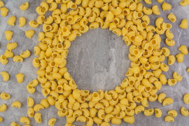 Mermer zemin üzerinde pişmemiş makarnalar izole edilmiş. Yüksek kalite fotoğraf