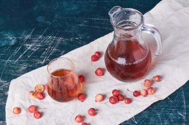 Mavi arka planda bir bardak içkisi olan kirazlar. Yüksek kalite fotoğraf