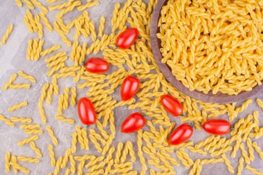 Pişmemiş pastalar ve gri arka planda kırmızı vişneli domatesler. Yüksek kalite fotoğraf