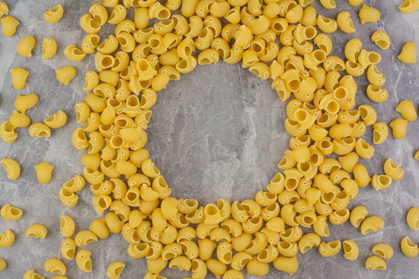 Mermer zemin üzerinde pişmemiş makarnalar izole edilmiş. Yüksek kalite fotoğraf