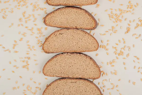 Beyaz zemin üzerinde yulaf taneleri olan dilimlenmiş taze kahverengi ekmek. Yüksek kalite fotoğraf