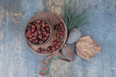 Kurumuş gül ve mermer kaplamalı çam kozalakları