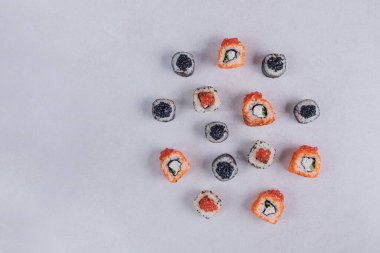 Maki ve California suşisi beyaz arka planda yuvarlanıyor. Yüksek kalite fotoğraf