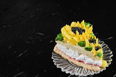 Siyah arkaplanda ayçiçeği şeklinde bir pasta. Yüksek kalite fotoğraf