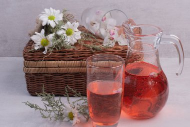 Beyaz zemin üzerinde ahşap bavul olan bir bardak kırmızı su. Yüksek kalite fotoğraf