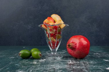 Nar, fötr şapka ve mermer masada bir bardak karışık meyve. Yüksek kalite fotoğraf