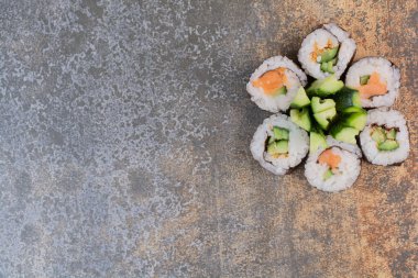 Mermer arka planda salatalıklı lezzetli suşi seti.