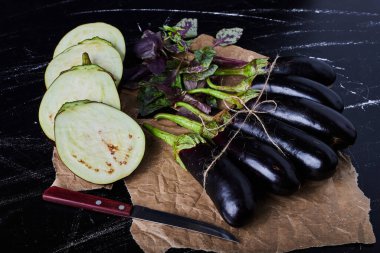 Siyah arka planda mor patlıcan ve yeşillik. Yüksek kalite fotoğraf