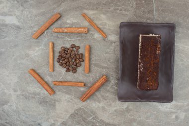 Bir dilim çikolatalı kek, kahve çekirdekleri ve mermer arka planda tarçın. Yüksek kalite fotoğraf