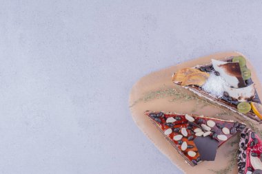 Kek dilimleri karamel, çikolata ve fındıklar ahşap bir tabakta. Yüksek kalite fotoğraf