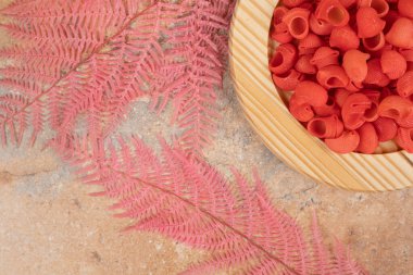 Hazırlıksız kırmızı makarna dolu ahşap bir tabak. Yüksek kalite fotoğraf