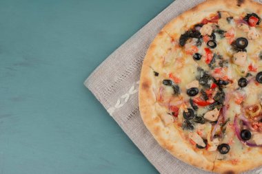 Mavi arka planda zeytinli ve domatesli lezzetli sıcak pizza. Yüksek kalite fotoğraf
