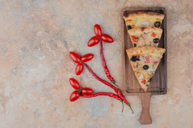 Masa arkasında domatesli ve biberli pizza