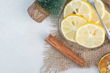 Çuval bezinde tarçın çubukları olan bir tabak limon. Yüksek kalite fotoğraf