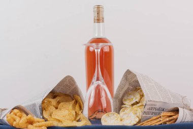 Beyaz masada çeşitli aperatiflerle birlikte bir şişe gül şarabı. Yüksek kalite fotoğraf